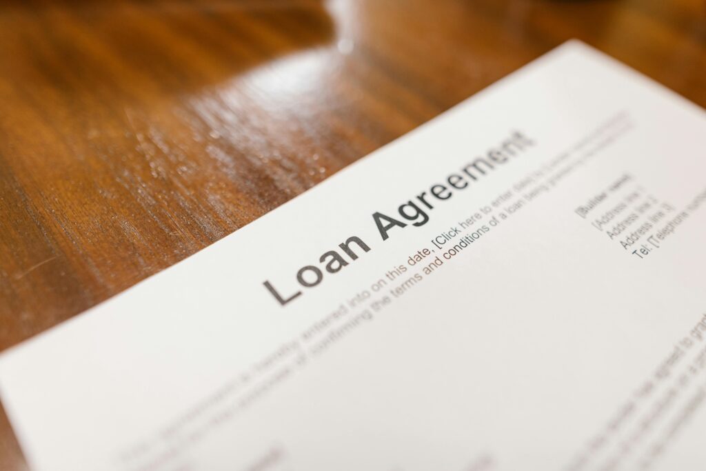 BUSINESS LOANS IN USA Detailed loan agreement document close-up on a wooden table representing legal and financial concepts.