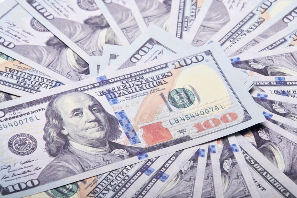 DEBT CONSOLIDATION PERSONAL LOAN A stack of hundred dollar bills spread out, symbolizing wealth and financial success.