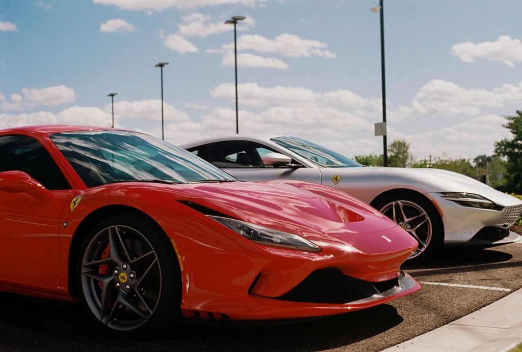 AUTO LOAN USA USED CARS CALCULATOR Red and white luxury sports cars parked on asphalt under a bright blue sky in St. Louis.