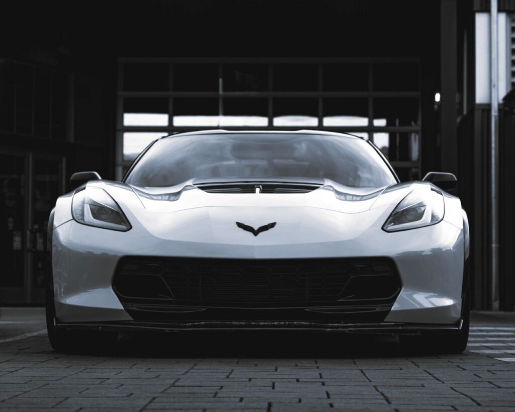 Dynamic front view of a sleek white sports car in an urban environment. Perfect for automotive design enthusiasts.