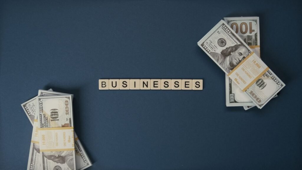 LOAN FOR A SMALL BUSINESS Top view of dollar bills and 'businesses' letter tiles symbolizing financial success.
