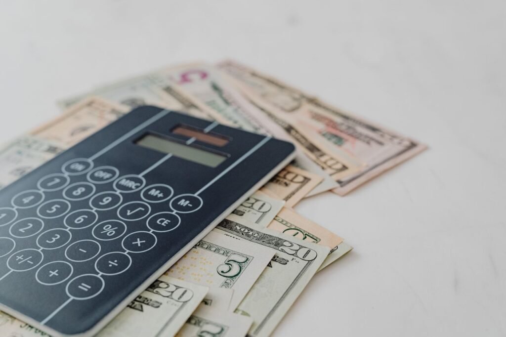 LOAN CALCULATOR A close-up of a calculator and US dollar banknotes, symbolizing financial calculation and budgeting.