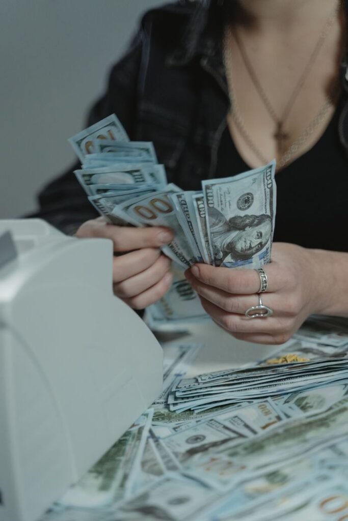 BEST PERSONAL LOAN A woman counting cash with a money counter, symbolizing financial management.