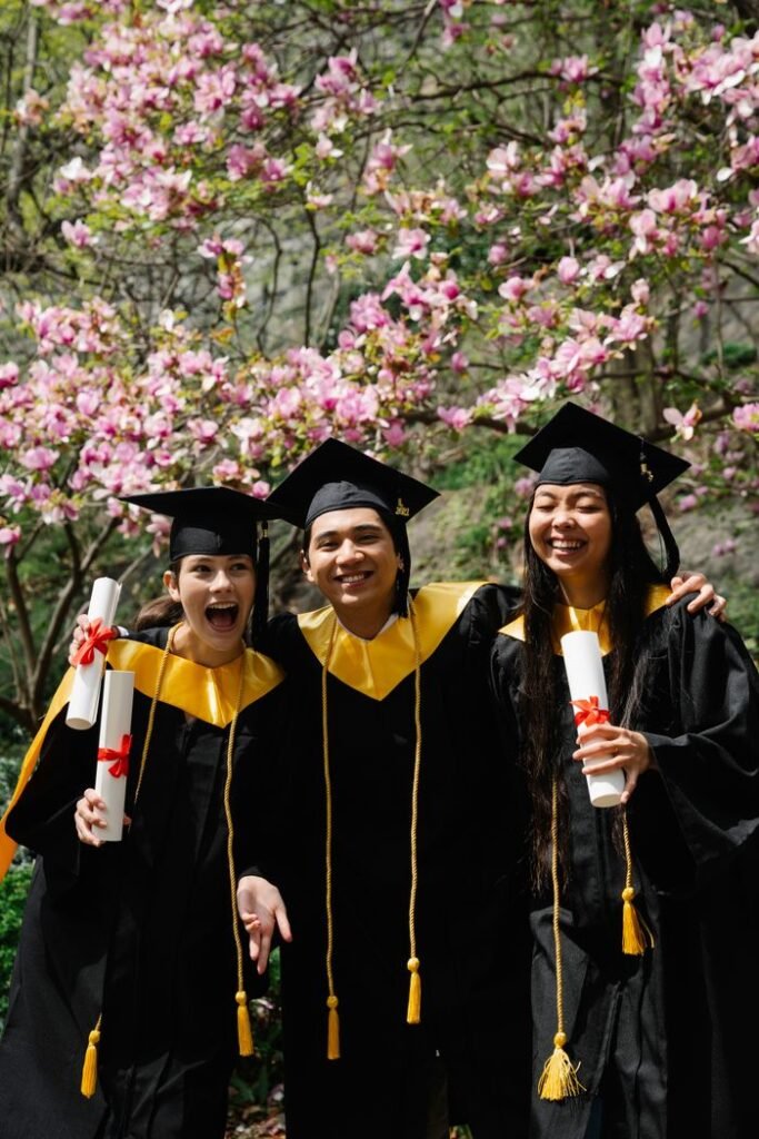 Joyful graduates in caps and gowns celebrating together with diplomas.