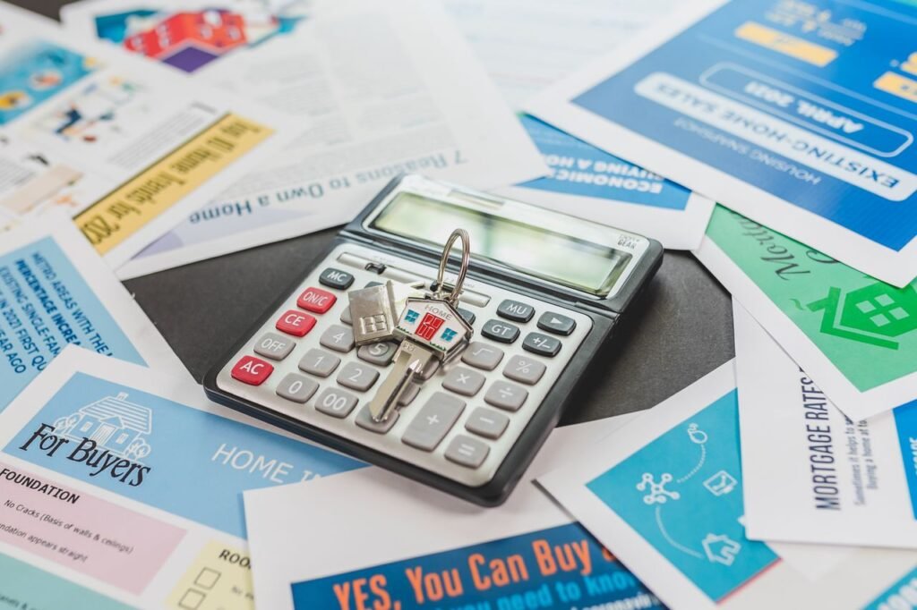 MORTGAGE CALCULATOR A calculator and real estate flyers depicting financial planning for home buyers.