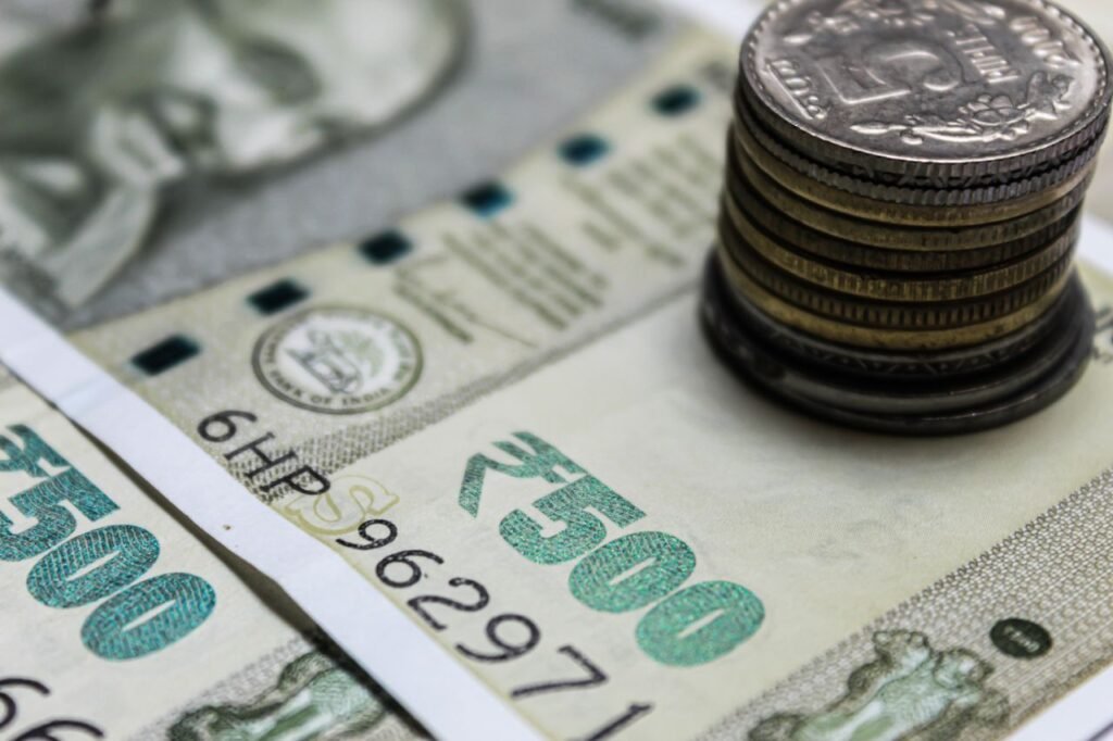 GET A PERSONAL LOAN Detailed view of Indian rupees and stacked coins, representing currency and finance.